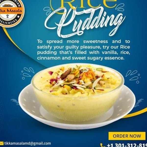 A bowl of creamy rice pudding topped with nuts and rose petals on a blue background.
